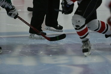 Hockey skates and stick on ice