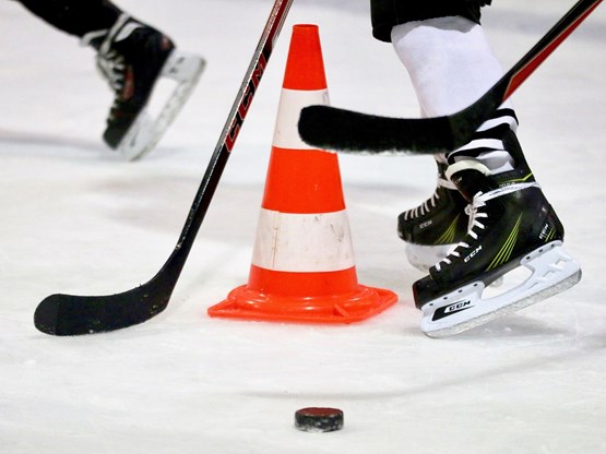 Hockey skates and sticks on ice with cone for drills